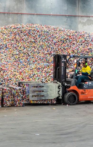 a person moving palettes of recycled waste with a forklift